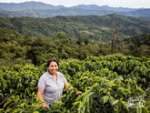Aramayo family member stands next to her coffee plants at Finca Rosita in Illimani, Caranavi.