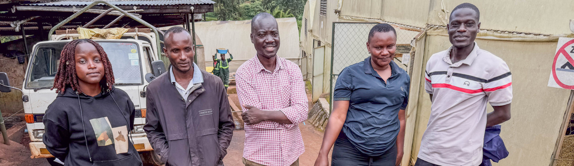 Five people who are part of the operations team at Gibuzale mill stand in line with mill manager Ramona, located far left.