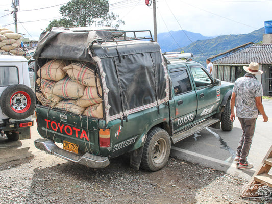 Outside a coffee buying operation in Buesaco, this truck's suspension is tested by a heavy load of dried parchment coffee during the harvest season .