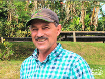 Marvin Barrantes stands in front of his raised drying beds at Reina Elizabeth.