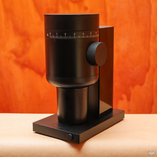 The Fellow Opus 2 Conical Burr Grinder has a low-key matte black design. The large adjustment knob makes it easy to precisely dial-in.