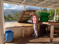 Byron Benevente lifts the lid on one of the coffee fermentation tanks at Finca La Florida, positioned right next to their green painted coffee depulper.