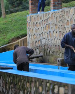 Workers wash the fruit mucilage from the green coffee seeds by agitating it with wooden paddles in washing channel. They also do a grade separation by continually pushing the coffee up stream, causing the heavy coffee to sink, while the light coffee float